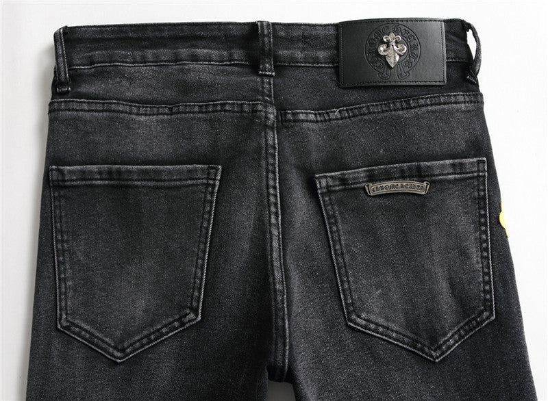 Back view of black washed denim jeans with two rear pockets and leather patch detail