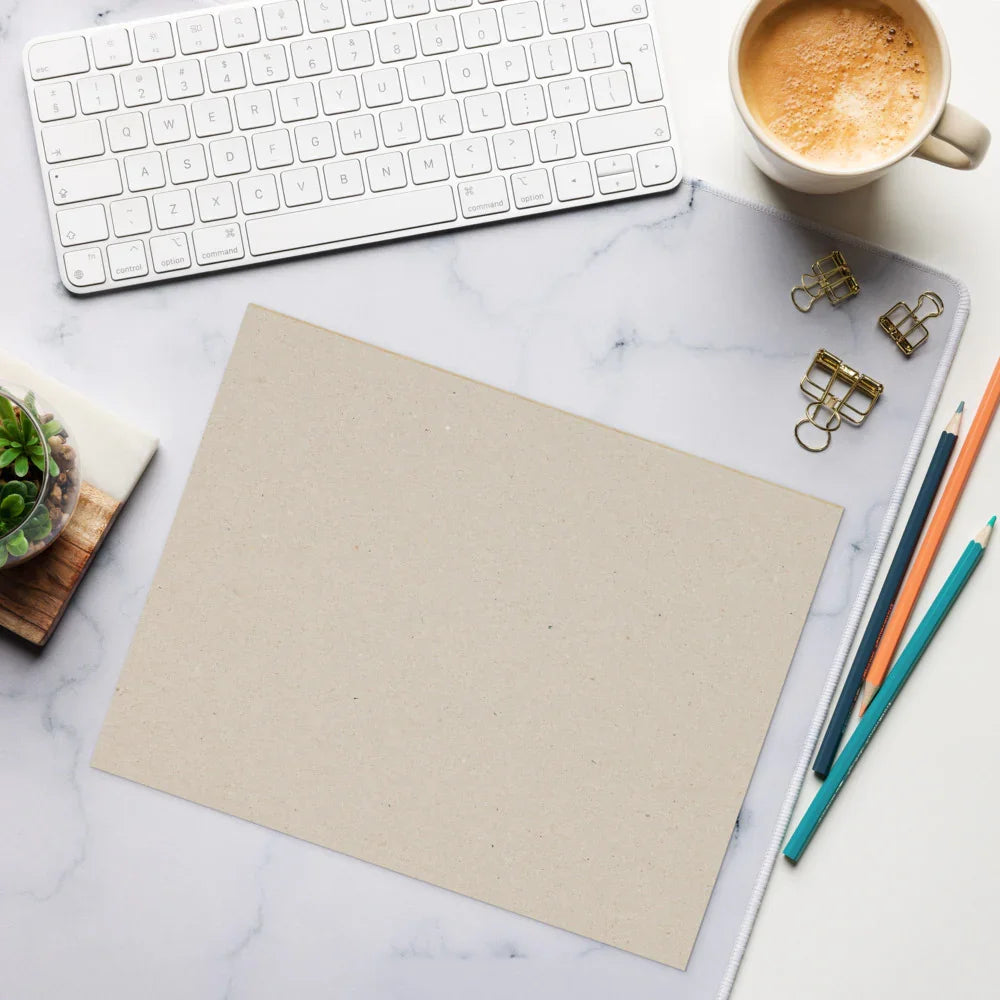 Blank sheet on marble desk with keyboard, coffee, pencils, binder clips, and succulent plant.