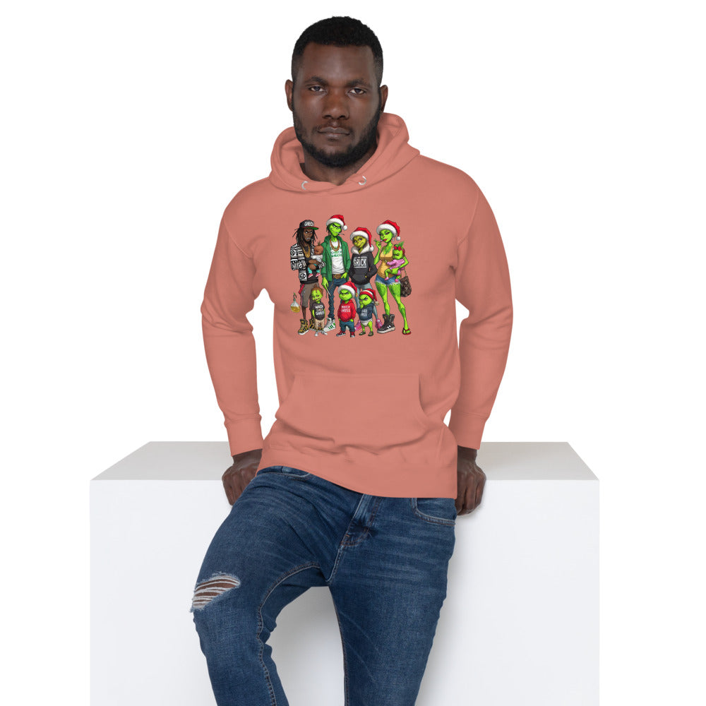 Man in salmon hoodie with graphic of colorful cartoon characters, wearing ripped jeans.