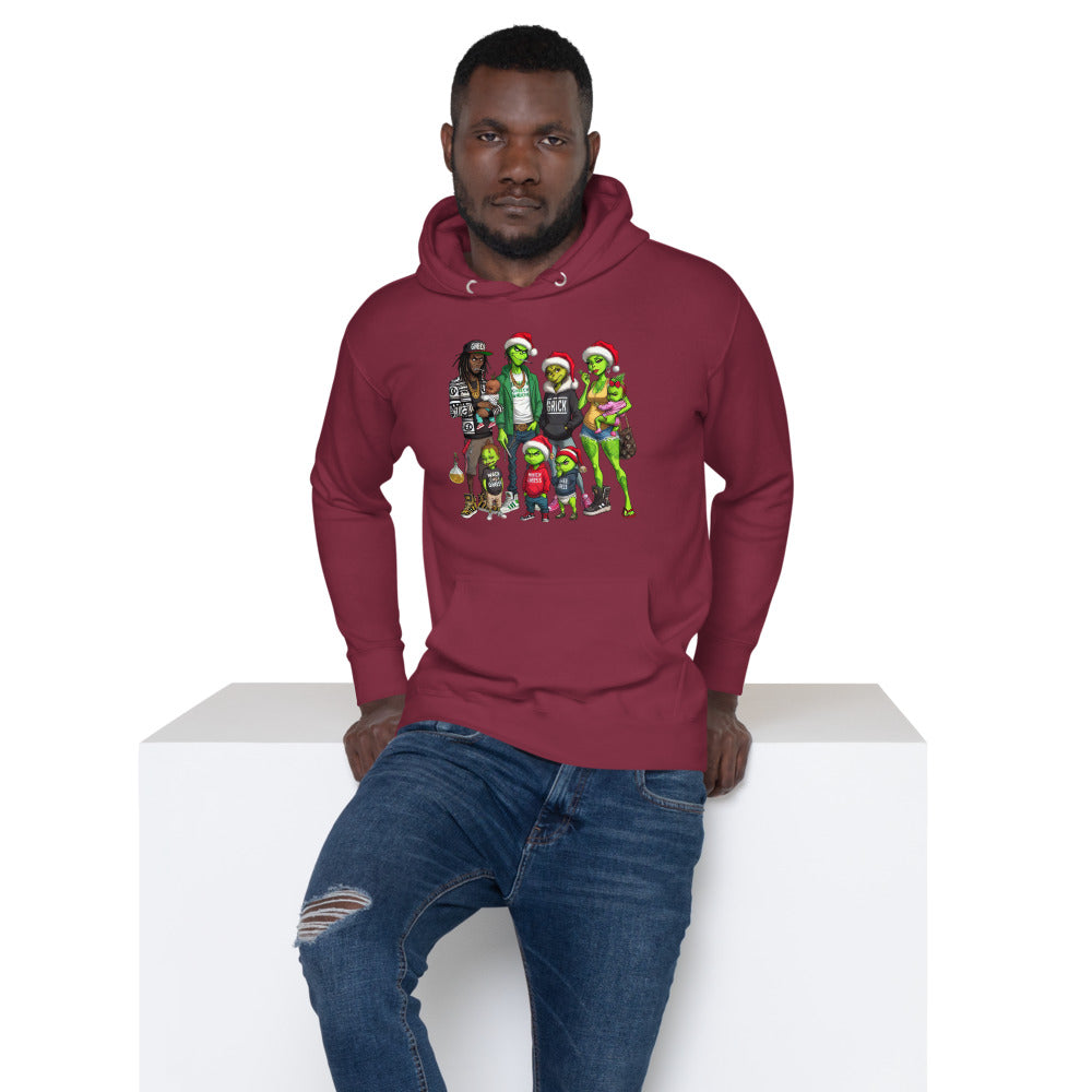 Man in maroon hoodie with colorful cartoon characters, sitting on white block, wearing ripped jeans
